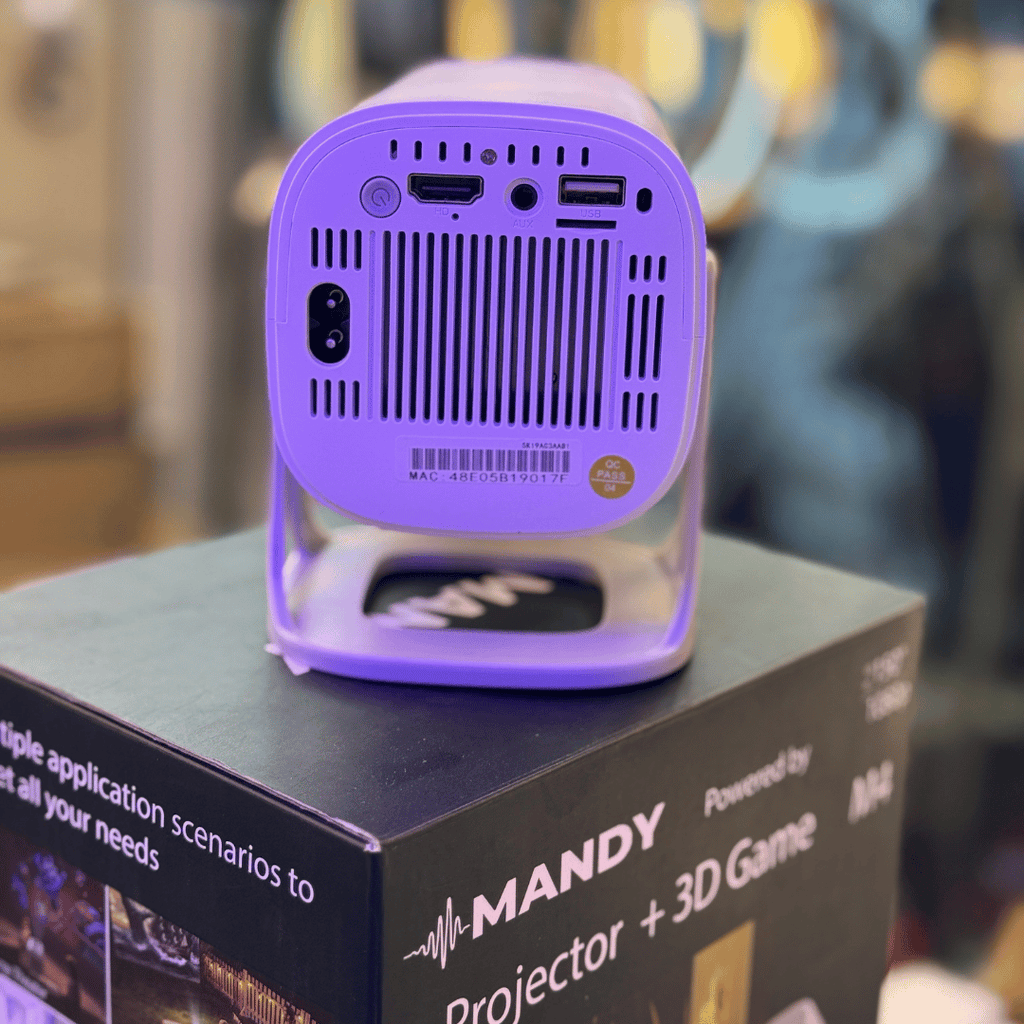 Purple Mandy smart mini projector on top of its packaging box with a blurred background