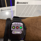 Mandy Android Smartwatch M12 on a wrist with app icons displayed, branded 'MANDY' in the background.