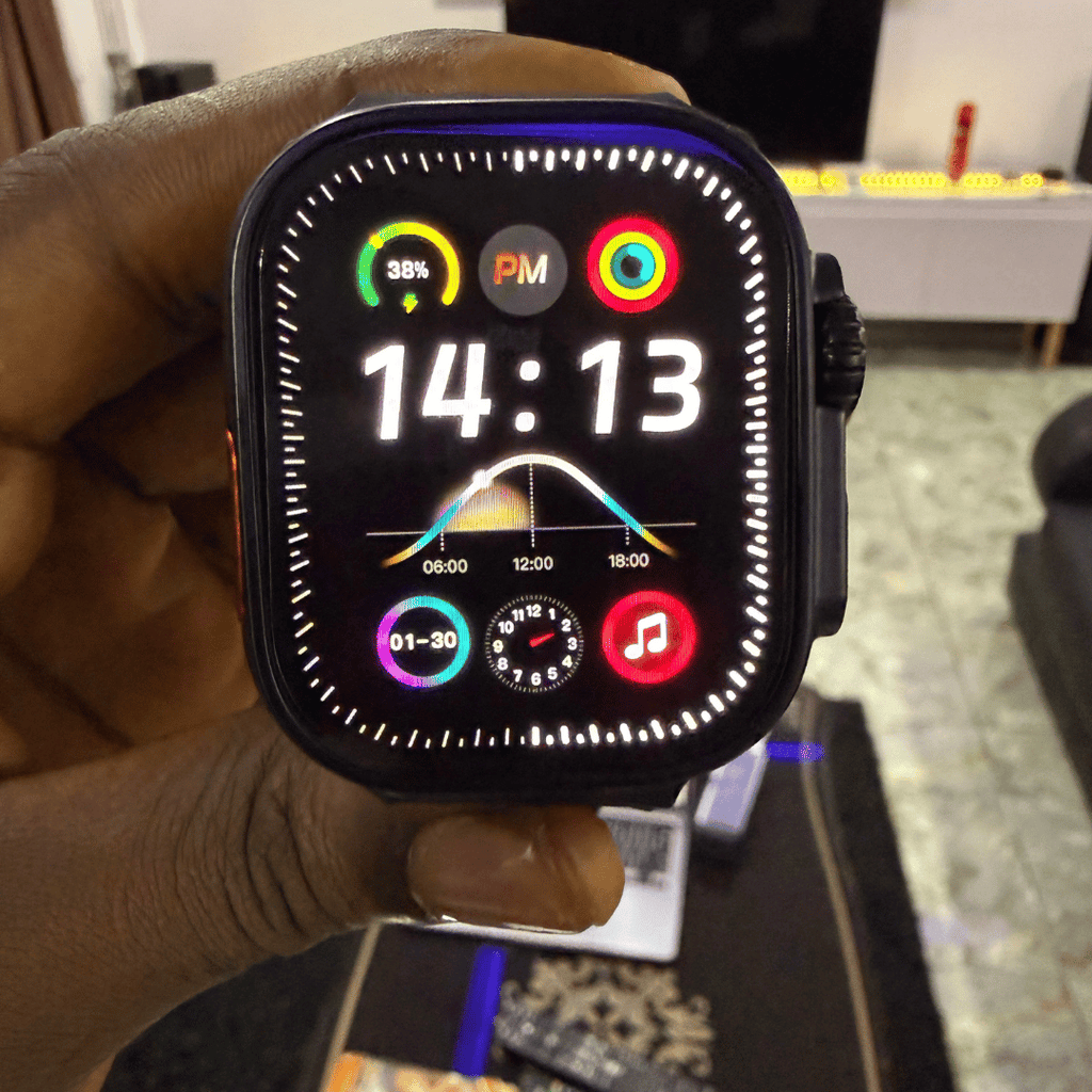 Mandy Android Smartwatch M12 with a colorful display held in a hand, blurred indoor background